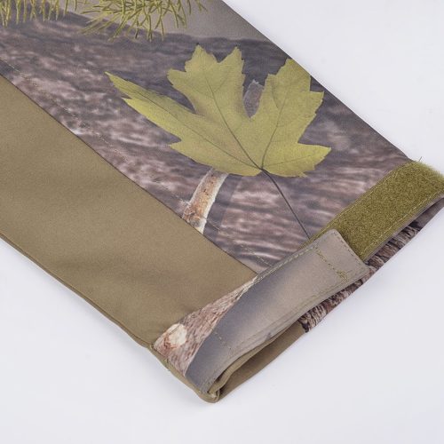 Water-resistant outdoor jacket with camouflage leaf print and adjustable Velcro cuffs. Perfect for workwear or outdoor activities, providing durability and comfort in various environments.