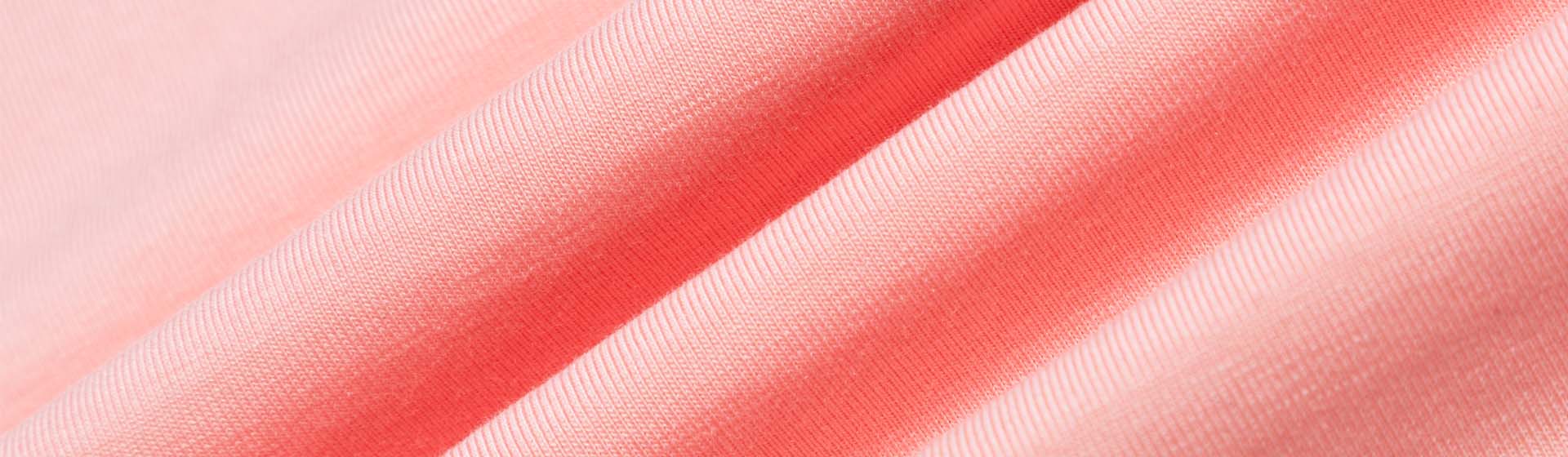 نسيج ناعم بلون الخوخ مع نسيج مضلع ناعم، مما يدل على جودة النسيج المستخدم في صناعة الزي الرسمي وملابس العمل المخصصة.