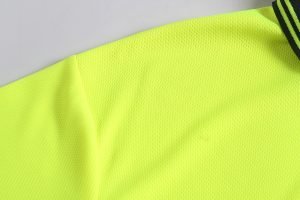 Bright yellow high-visibility safety fabric for custom work uniforms, reflecting safety standards in construction and industrial environments.