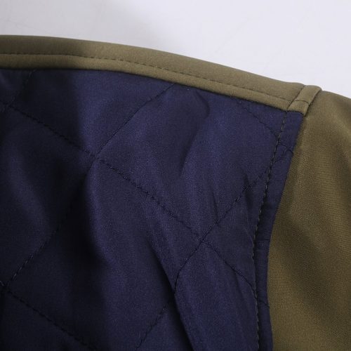 Dark blue quilted fabric section of a work jacket with khaki green outer fabric, showcasing durable stitching and high-quality material.