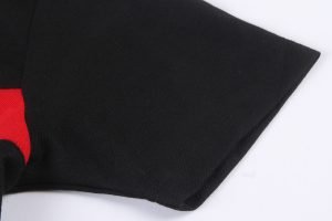Black workwear fabric with red accent for custom uniforms and clothing manufacturing. Durable textile suitable for various professional workwear applications.