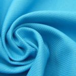 Vibrant blue technical fabric with a smooth, textured surface, ideal for custom workwear uniforms and apparel manufacturing. Perfect for high-performance and durable work clothing.