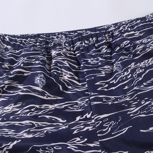 Comfortable navy blue shorts with a white abstract lion and wave pattern, featuring elastic waistband and button closure, ideal for casual wear or beach outings.