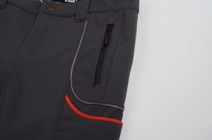 Black workwear pants with red accents, multiple pockets, and durable zippers for industrial and professional use. Designed for comfort and practicality in tough work environments.