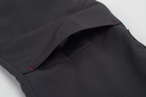 Dark black work uniform fabric with a pocket detail, designed for durability and comfort, suitable for professional industrial environments.