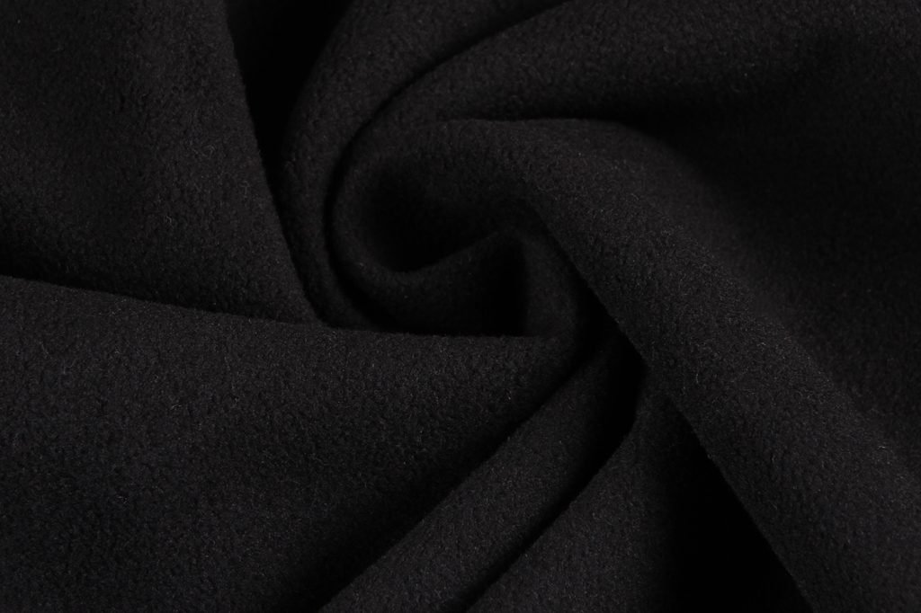 Soft black fabric close-up, high-quality material used for custom uniforms and workwear, showcasing durability and comfort for professional clothing needs.