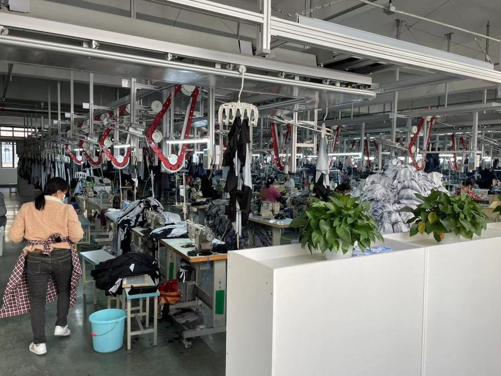 High-capacity garment factory in China specializing in custom workwear and uniforms with modern sewing machines and organized production lines.