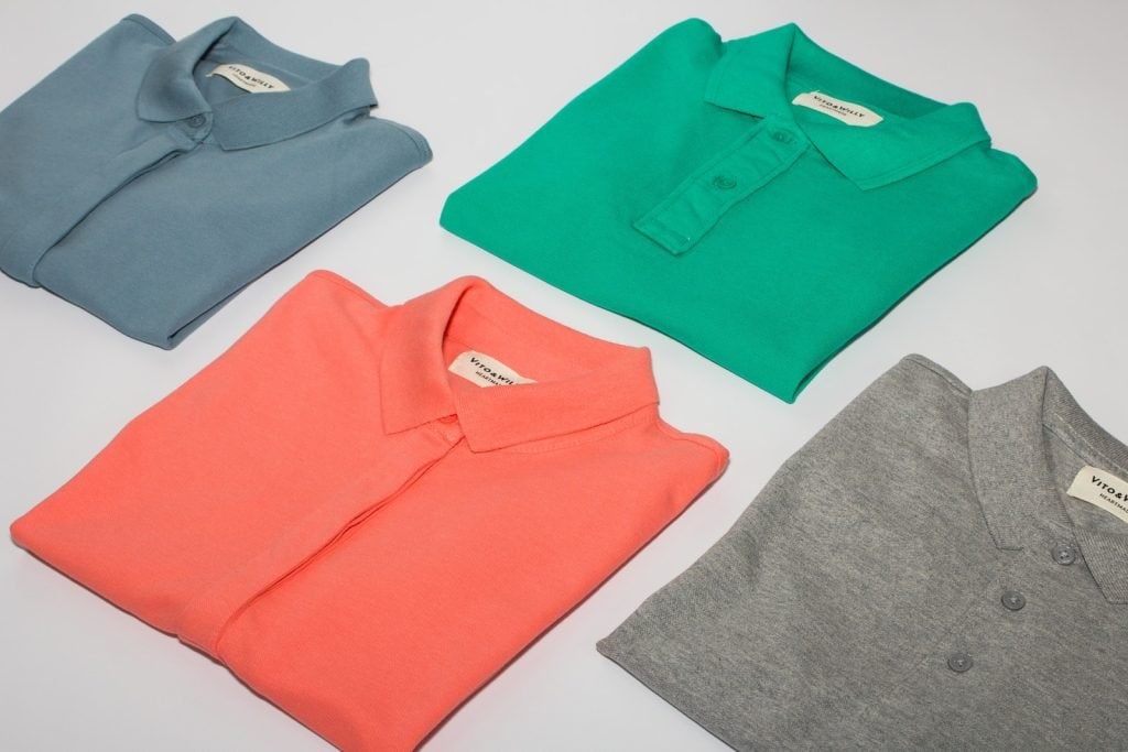 Soft pastel-colored polo shirts neatly folded for workwear uniforms - ideal for corporate branding and uniform customization.