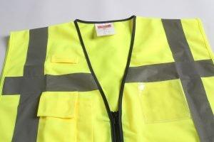 High-visibility safety vest with reflective strips, multiple pockets, and zipper closure for construction, industrial, and safety workers. Customizable workwear made in China.
