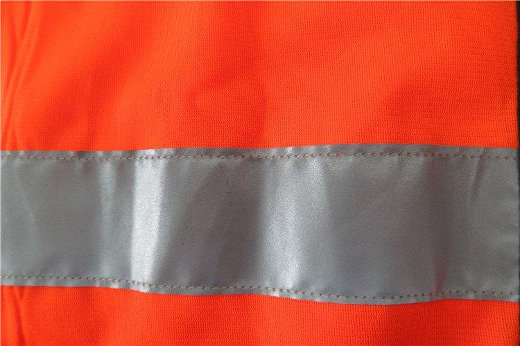 Reflective safety stripe on bright orange workwear uniform for high visibility and safety.