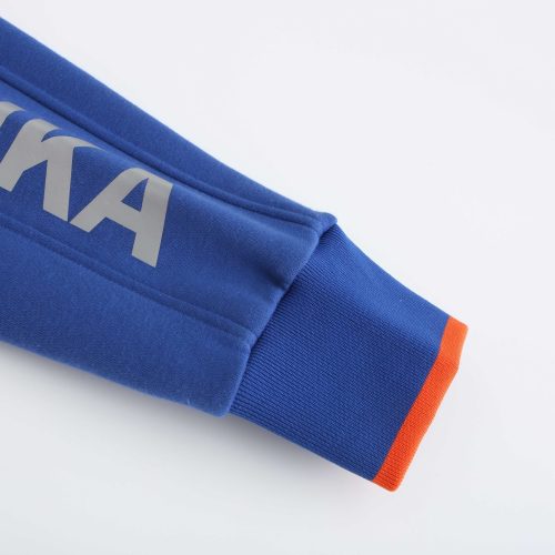 Bright blue sports jersey sleeve with "SUKA" logo, featuring orange accent at the cuff, showcasing high-quality athletic apparel designed for customization and professional sports teams.
