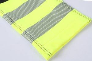 High-visibility safety vest with reflective strips, designed for construction and industrial workers, offering enhanced visibility and safety in low-light conditions.