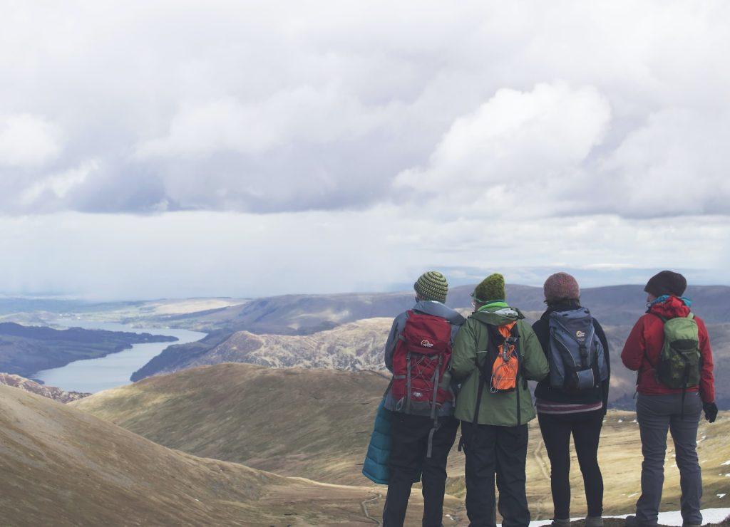 Men hiking in outdoor mountain landscape with backpacks and outdoor gear, enjoying adventure in nature.