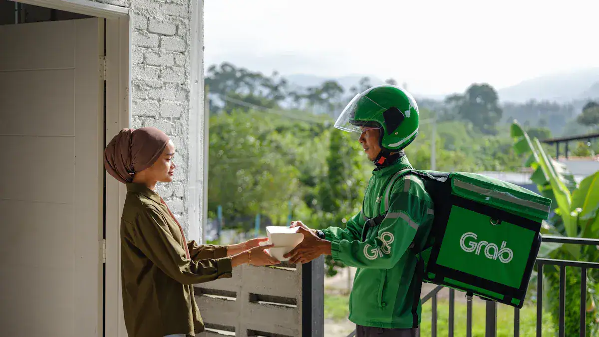 Delivering food to a woman from a Grab driver in uniform holding a food container outside a house, showcasing customized delivery uniforms from a China-based manufacturer for Grab delivery staff.