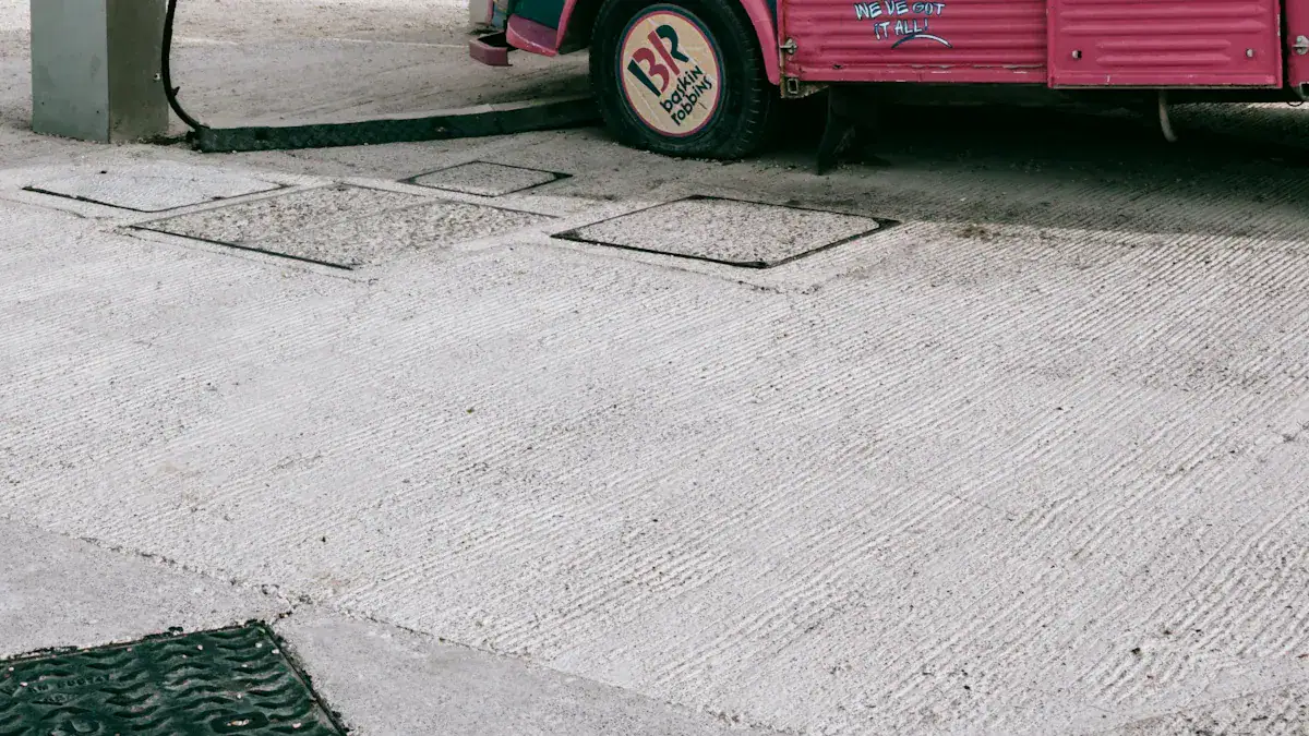 Concrete sidewalk with open manhole covers next to a pink food truck, emphasizing durable workwear and uniform manufacturing solutions from a China-based custom clothing supplier.