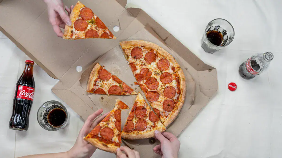 Slices of pepperoni pizza being shared among people, with soda and a glass of cola on a white table.