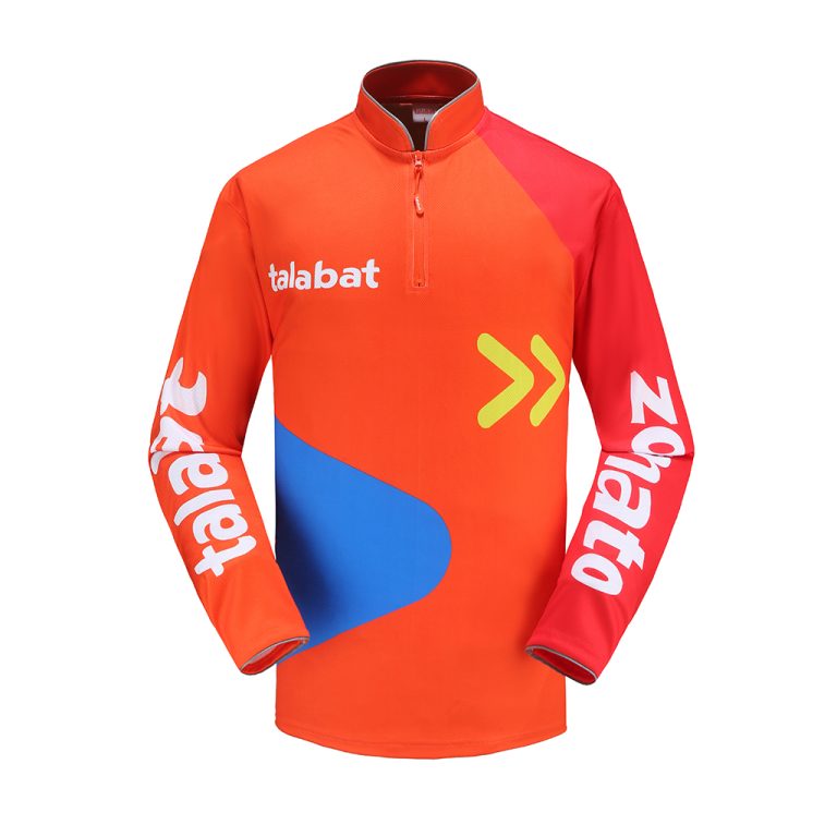 Chaqueta deportiva personalizada de color naranja brillante y rojo con la marca "talabat", con un cuarto de cremallera, gráficos llamativos y logotipos colocados, diseñada para uniformes de equipo y prendas promocionales.