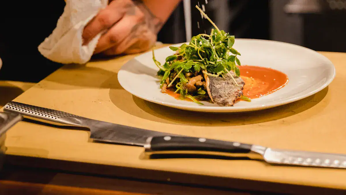 Freshly plated gourmet dish with greens, fish, and sauce on a white plate; artistic presentation of modern cuisine.