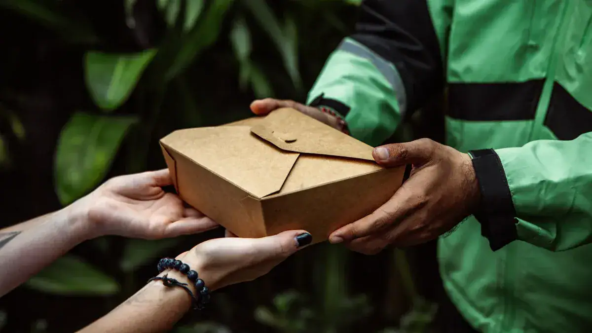 Handing over a food delivery box in an outdoor setting, showcasing the importance of professional foodservice uniforms and apparel manufacturing.