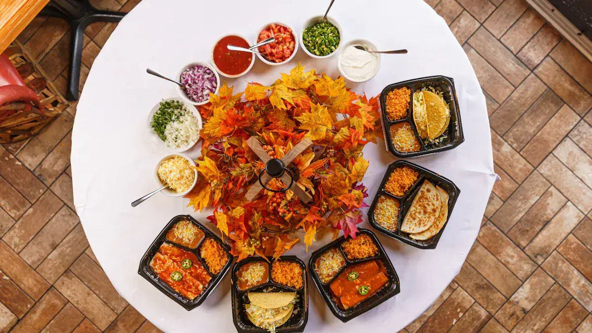 Butternut squash soup with salsa, sour cream, and chopped herbs, served with multiple tacos on a black tray, surrounded by a colorful autumn leaf centerpiece on a white tablecloth.