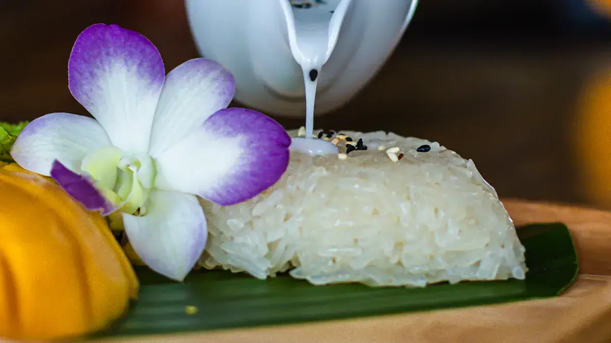 Creamy coconut sticky rice served with tropical fruit and edible flower, showcasing Asian cuisine presentation.