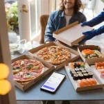 Freshly delivered pizza and sushi boxes on a table with a delivery person handing over the food to a smiling customer, showcasing food delivery service.