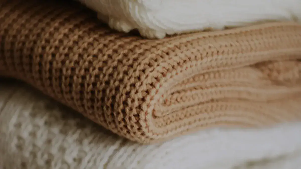 Luxurious folded fabric in neutral tones showcasing textured woven material suitable for custom workwear uniforms and garments from a trusted China manufacturer.