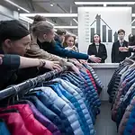 Colorful winter jackets on display racks at a clothing manufacturing showroom in China.