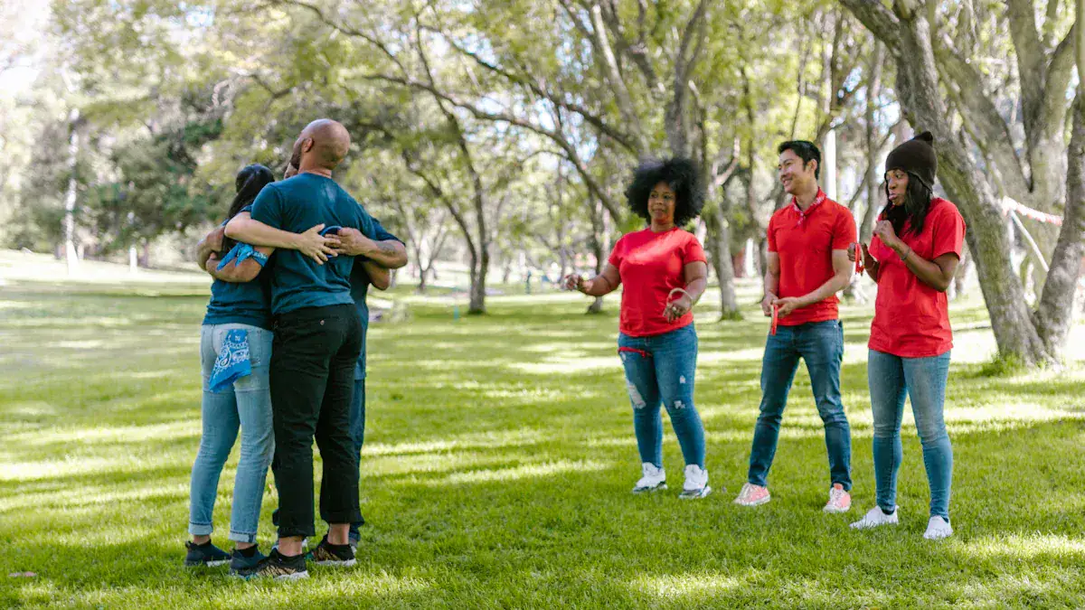 Vibrant outdoor scene of diverse group in colorful work uniforms embracing and celebrating together in a lush park setting.