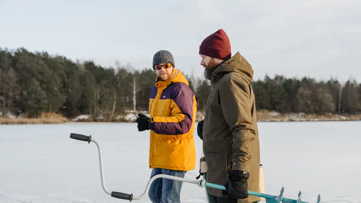 Warm winter outdoor clothing for men, featuring insulated jackets and accessories, on snowy landscape with a ice ice fishing activity.