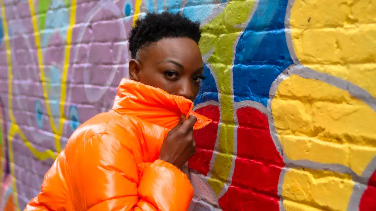 Bright orange custom down jacket for workwear, stylish apparel for outdoor activities, fashionable and warm outdoor clothing for men and women, high-quality custom uniforms for various industries.