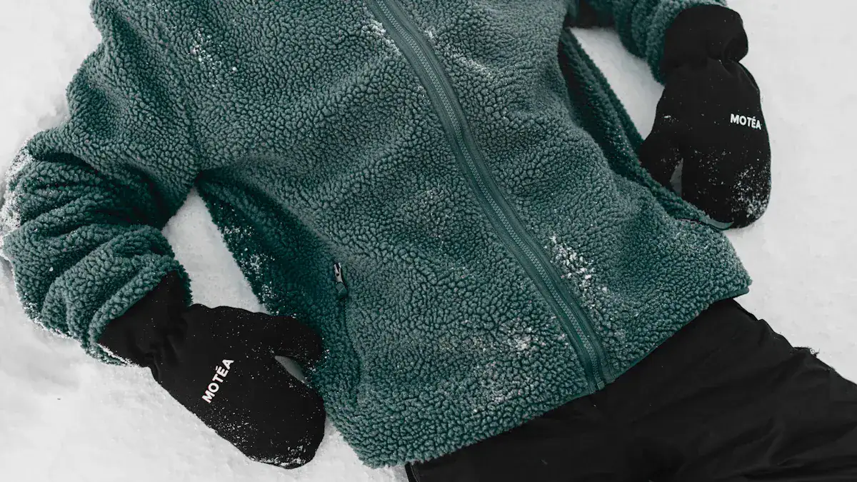 Warm fleece jacket and branded gloves worn in snowy outdoor setting for winter workwear, showcasing customizable uniforms from a China-based manufacturer.