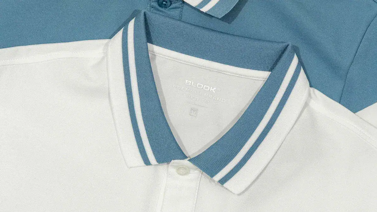 Bright white polo shirt with blue striped collar, made from high-quality fabric for casual or professional uniforms. Customizable options available for bulk orders.