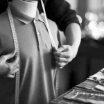 Precise measurement of a custom uniform being taken in a tailoring workshop.