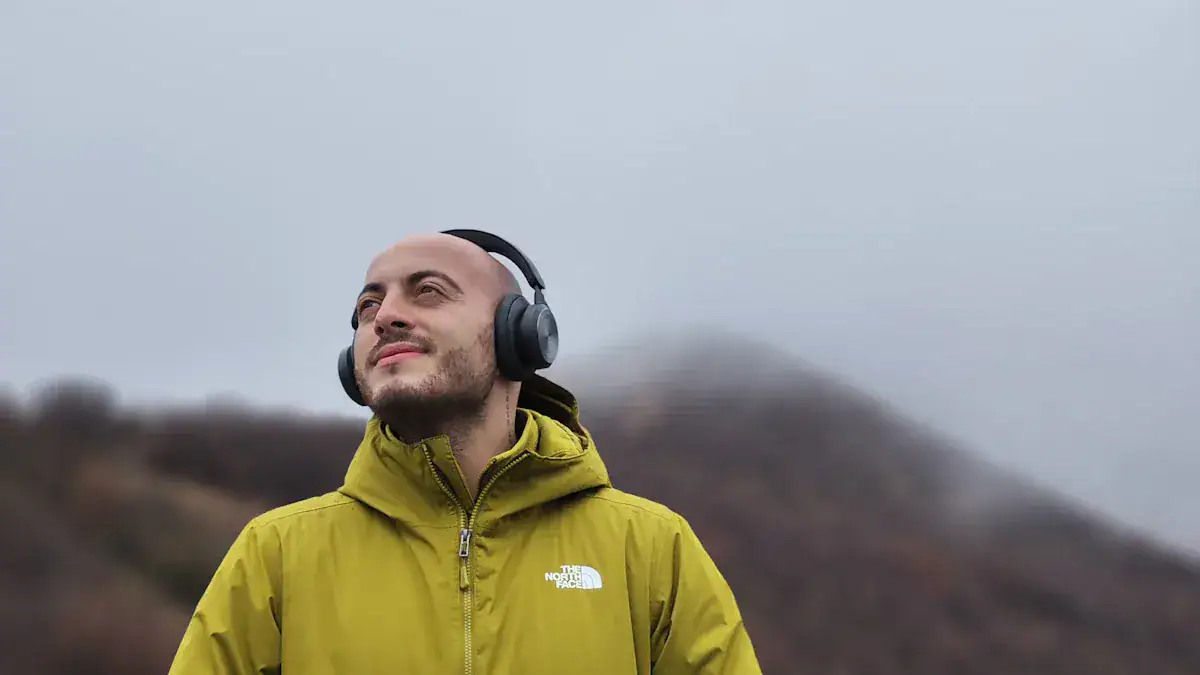 Men wearing yellow outdoor jackets and headphones, enjoying nature in a scenic landscape for outdoor activity or hiking.