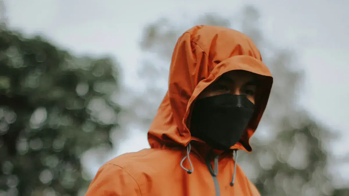 High-quality orange waterproof jacket with hood, breathable fabric, and adjustable drawstrings for outdoor and workwear use. Perfect for protection against rain and harsh weather conditions.