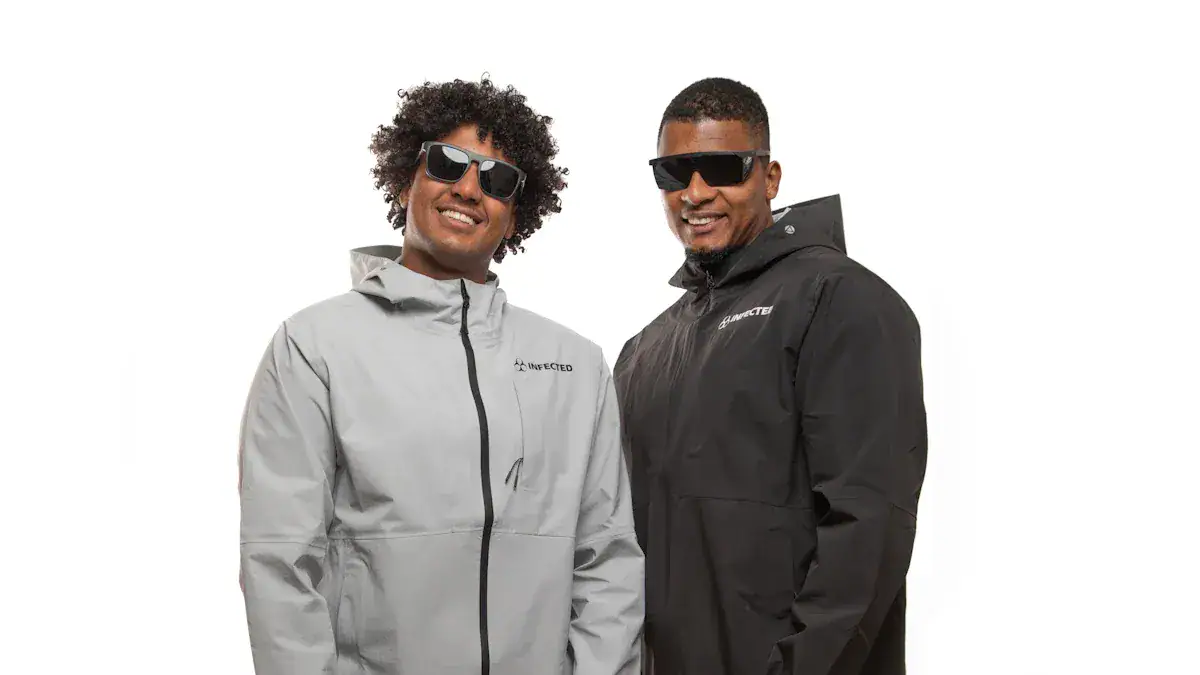 Light grey and black custom outdoor jackets with sunglasses worn by two smiling men, showcasing durable, stylish uniforms from a China-based workwear manufacturer.