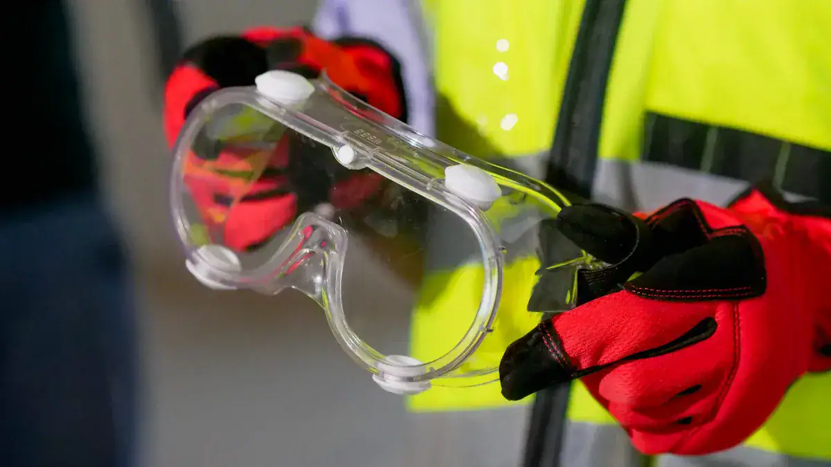 Safety goggles and high-visibility work jacket for industrial or construction safety.