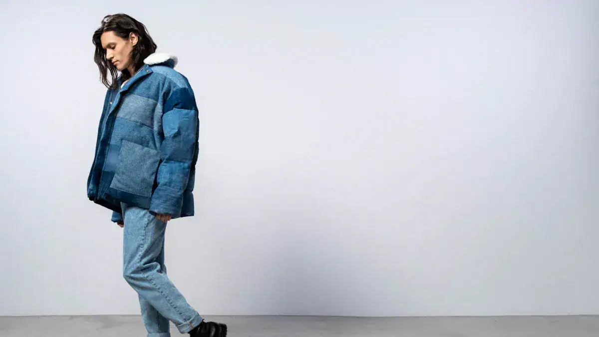 Patchwork blue puffer jacket with hoodie, casual streetwear style, worn by a woman against a neutral background.
