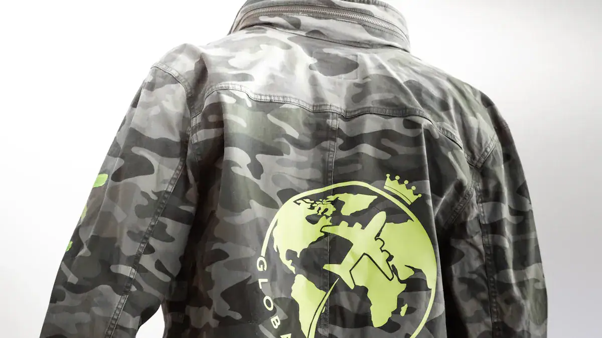 Custom camouflage work jacket with globe and airplane logo, suitable for industrial or aviation uniforms. Made in China by a trusted manufacturer, customizable for corporate branding.