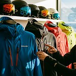 Bold and colorful ski jackets with helmets on display at a sports shop, showcasing custom outdoor winter wear for skiing and snowboarding enthusiasts in China.