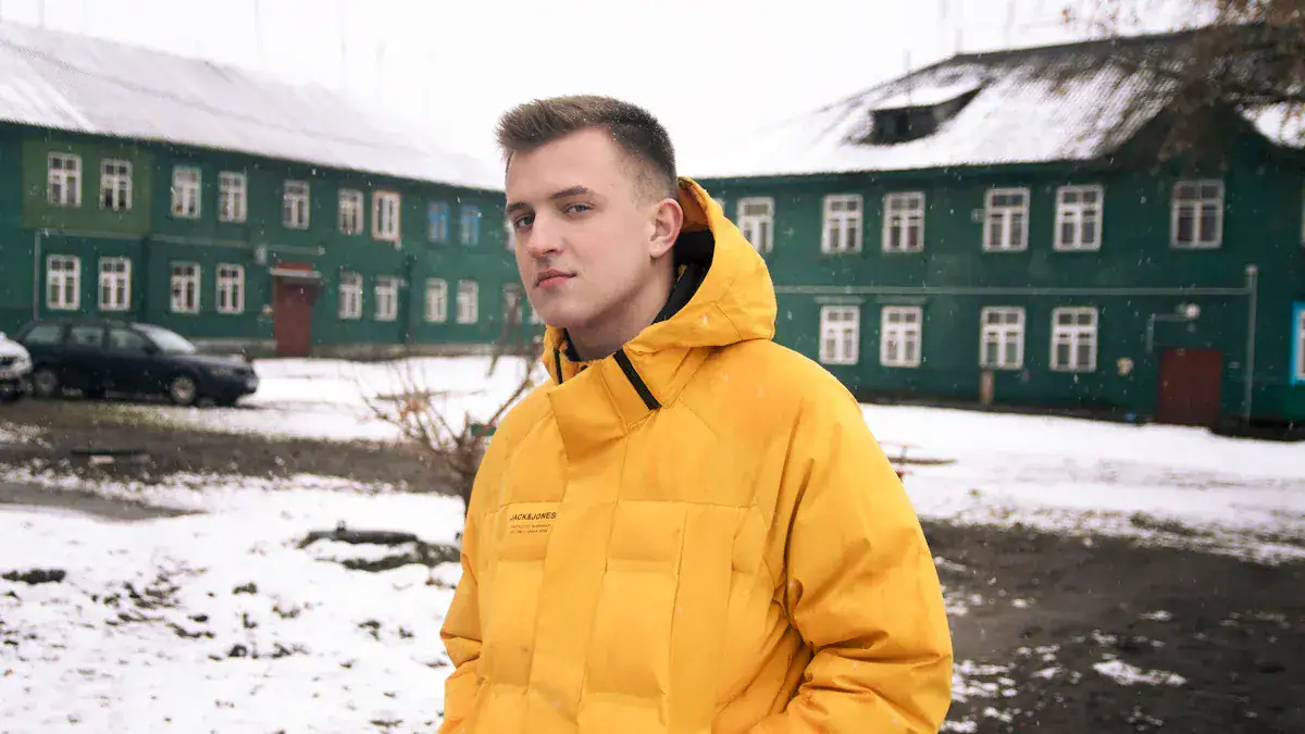 High-quality yellow custom work jacket worn outdoors in winter, showcasing durable, waterproof workwear ideal for construction, industrial, or outdoor jobs in cold weather conditions.