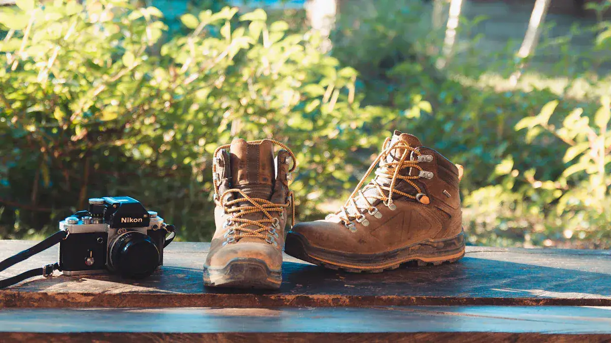 Durable brown hiking boots with rugged soles and a Nikon camera on a wooden surface outdoors.