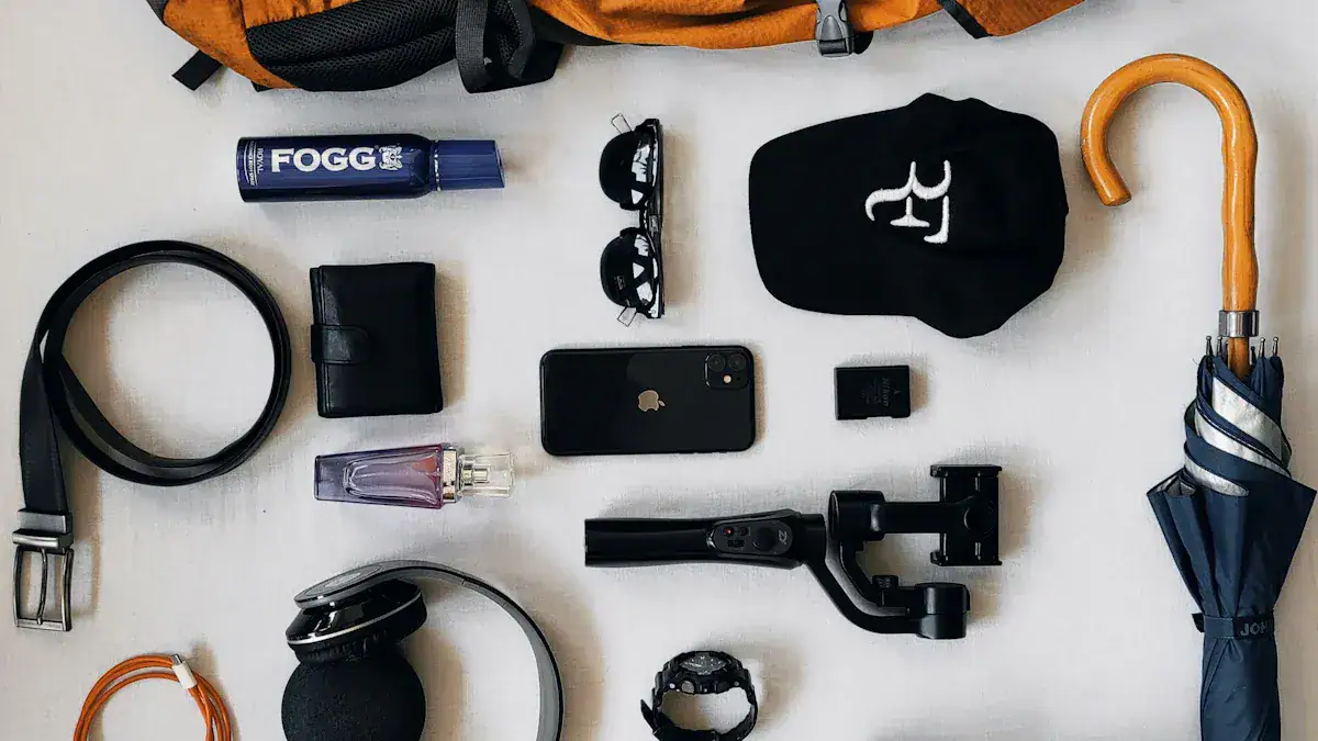 Wireless headphones, smartphone, sunglasses, wallet, umbrella, wristwatch, perfume, camera stabilizer, deodorant, bag, and other personal accessories laid out on a flat surface.