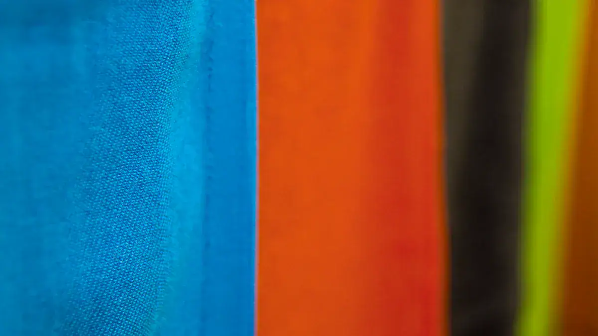 Vibrant blue, orange, black, and yellow fabric swatches for custom work uniforms and clothing, showcasing quality textiles offered by a professional China manufacturer.