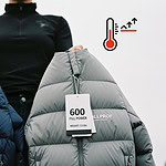 Down-filled insulated jackets displayed for custom workwear manufacturing, featuring tags with fill power ratings of 600 and 800 for superior warmth and durability.