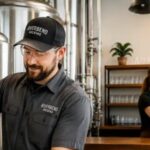 Adult brewery plant and taproom staff in branded workwear uniforms